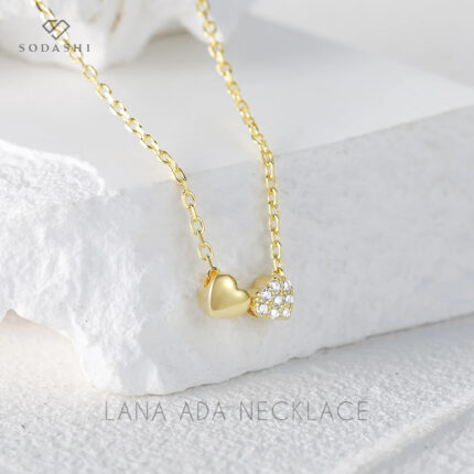 Introducing the exquisite Lana ADA Necklace by Sodashi. This beautiful piece features a double heart smooth and cubic zirconia charm design, elegantly paired with a thin chain. Available in both gold and silver plating, the necklace is crafted from high-quality sterling silver. With a chain length of 45CM, it is the perfect accessory to add a touch of sophistication and charm to any outfit. Discover the elegance of the Lana ADA Necklace and make it a cherished addition to your jewelry collection.